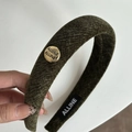 Detailoverzicht van mosgroene fluwelen haarband met gouden logo en streeptextuur - Haarband / Groen Hoofdband met Goud Logo