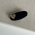 Detailopname van de fluwelen haarclip met een goudkleurig metalen hart en Alline-gravure - Haarclip / Zwart Ovalen Haarclip met Goud Hart