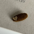 Detailed close-up of velvet hair clip featuring a gold heart with engraved lettering - Caramel Oval Hair Clip with Gold Heart