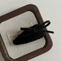 Dettaglio macro di un fermaglio nero con fiocco in pelle su sfondo di lino - Fermaglio Fiocco Goccia d'Acqua Nero