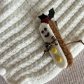 Close-up of plush gingerbread man Christmas hair clip on soft knit background - White Cookie Black Glasses Leaf Headband