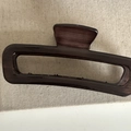 Gros plan d'une grande pince à cheveux marron foncé avec un design vintage texture bois - Style Rectangulaire Brun