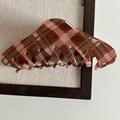 Dettaglio di un grande fermaglio per capelli marrone a scacchi vintage con finitura lucida - Stile Zucca Lunga A Righe Rosse E Bianche