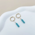 Gros plan de boucles d'oreilles dorées avec perles claires et cylindres turquoise - Style Bleu Ciel (TL-E0100-02-blue)