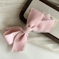Detailed view of pink fabric bow hair clip featuring delicate ruffled edge design - Pink Bow Hair Clip / Pink