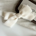 Detailed close-up of cream white fabric bow hair clip with ruffled lace edges - Creamy White Bow Hair Clip / Milky White