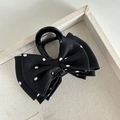 Dettaglio della pinza per capelli con fiocco a pois neri e bianchi su vassoio beige - Pinza Capelli Pois Bianco Fiocco Nero