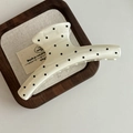 Primer plano de pinza para el pelo color crema con lunares negros en bandeja madera - Clip Blanco Crema Forma Percha Mota Negra