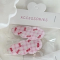 Detail of two cloud-shaped hair clips with cherry prints in retail packaging - Pink Grid Cherry