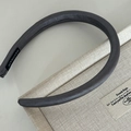 Minimalist deep grey padded headband with textured leather finish and handmade label detail - Glossy Gray