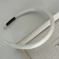 Detail shot of the white satin headband showing the handmade label and soft padded texture - Bright White