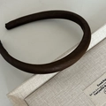 Dettaglio del cerchietto in raso marrone scuro spesso con elegante texture imbottita - Marrone Lucido