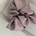 Detail of satin fabric texture and pleated layers of the dusty pink scrunchie - Pink