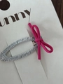 Vista dettagliata di un fermaglio per capelli intrecciato argento con un fiocco in pelle scamosciata rosa - Rosa Rosso