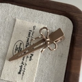 Detailed close-up of a brown polka dot bow hair clip on rustic fabric and wood - 3# Large Milk Tea Duckbill Clip Milk Tea Bow