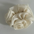 Detailed view of the layered pleated organza rose scrunchie in elegant cream white - White