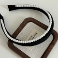 Dettaglio di un cerchietto nero largo con perle bianche eleganti su un vassoio di legno - Cerchietto Nero Con Bordo Di Perle