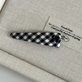 Detail of British style black and white checkered hair clip with small bow on linen base - Black and White Checkered Long Triangle with Black Bow