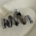 Detail of grey ink-wash marbled acetate hair claw clip with wavy edge on ceramic tray - Grey M-Shaped Wavy Claw Clip