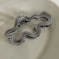 Detail view of wavy irregular grey acetate claw clip with frosted texture and silver spring - Grey Irregular Claw Clip