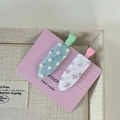Close-up of two floral acrylic hair clips in blue and white on a pink display card - White Flower Blue Clip Pink Flower White