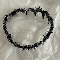 Dettaglio del cerchietto nero in tessuto testurizzato con fili argentati e dentini antiscivolo - Nero Bianco