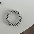 Close-up of spiral hair tie with black polka dot patterns in clear plastic material - Transparent Large Black Polka Dot Style