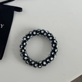 Close-up of black spiral hair tie with white polka dots on a clean white background - Black White Polka Dot Style