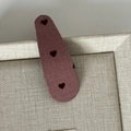 Dettaglio di un fermaglio per capelli in tessuto viola con tre cuori rossi su vassoio beige - Fermaglio BB a Goccia / Fermaglio Cuore Goccia Rosa Lampone