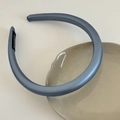 Primer plano de diadema de satén azul claro con etiqueta artesanal en plato cerámico - 2cm / Azul