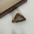 Dettaglio macro della molletta a triangolo in resina marrone con fiocco decorativo chic - Clip a Artiglio Bottone Triangolo Tè al Latte