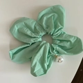 Dettaglio dell'elastico floreale verde menta con texture in tessuto e ciondolo a perla - Verde