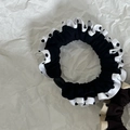 Dettaglio macro di elastici retrò a pois con bordi a contrasto increspati su sfondo bianco - Nero con Pois Bianco Neri