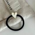 Dettaglio dell'elastico nero per capelli con ciondolo a cuore in resina color crema - Stile Cuore Bianco