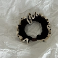 Dettaglio di elastico nero con bordo a pois bianchi e perlina decorativa marrone - Nero con Bordo Caffè