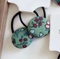 Détail d'un élastique en tissu à fleurs avec petites fleurs rouges et blanches sur vert - 1# Chouchou Boule Florale Verte (Paire)