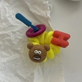Detailopname van een gele spiraalvormige haarelastiek met een beertje en paarse knoop - Lichtgeel (H)