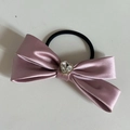 Dettaglio di un elastico in raso rosa con strass a forma di cuore scintillante al centro - Elastico Fiocco Viola