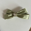 Dettaglio del fermaglio per capelli in raso verde con cristallo a cuore scintillante - Clip Fiocco Cuore Verde