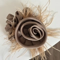 Dettaglio di un elegante scrunchie rosa in raso marrone moka con accenti di piume - Elastico Capelli Fiore Tè al Latte Piuma