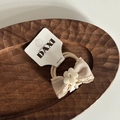 Dettaglio di elastico per capelli con fiocco fatto a mano e perla su vassoio - Elastici per Capelli Fiocco Fiore Tè al Latte