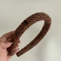 Detail eines Vintage-Strickstirnbands aus brauner Wolle mit rotem Seidenwebmuster - Kaffee Orange Gestreifter Stil (Rote Schleife)