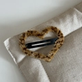 Close-up of heart-shaped leopard print plush hair clip on a beige fabric background - Light Leopard Heart