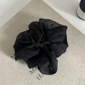 Detailed macro shot of a black polka dot organza scrunchie on a minimalist book cover - Black (5#)
