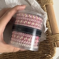 Primer plano de un set de gomas de pelo trenzadas multicolor en una caja cilíndrica transparente - 11# Serie Rosa