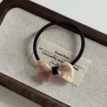 Detail of pink marble acetate bow hair tie on a wooden tray with aesthetic lighting - Pink White Texture Bow Hair Tie