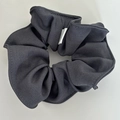 Detail view of dark grey fabric scrunchie texture with high-quality stitching and label - Hair Ties Set / Gray