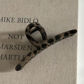 Dettaglio della grande molletta per capelli leopardata su uno sfondo di libro minimalista - 4# Leopardo Chiaro Grande Incrociato