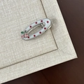 Detailed view of an oval polka dot hair clip with sparkling cherry rhinestone accents - White Red Dot Oval Hollow Pink Cherry