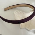 Diadema de satén morado oscuro con placa de plata sobre plato de cerámica blanca - Caqui